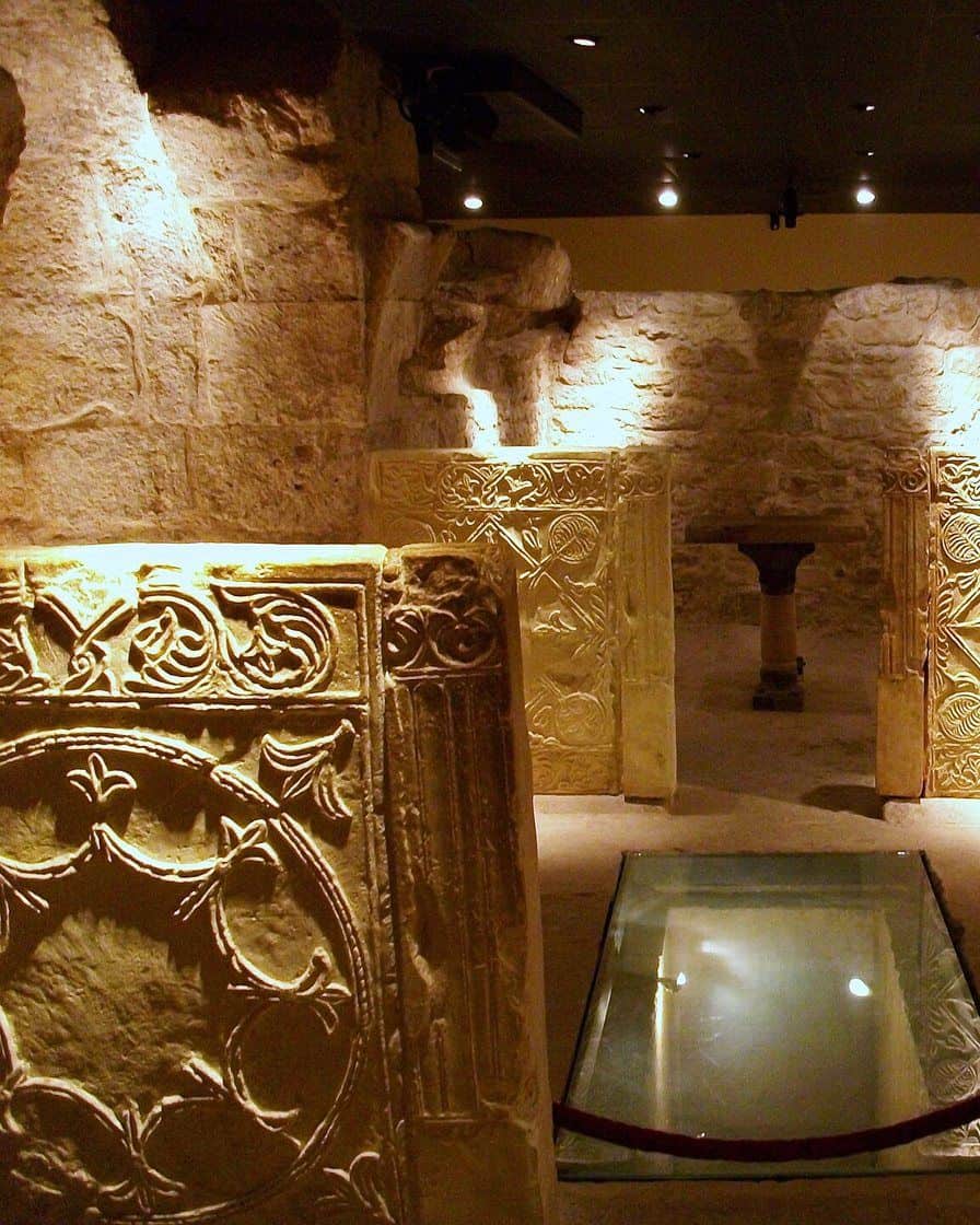 Interior abovedado de la Cripta de San Vicente Mártir en Valencia, con muros de piedra romana y visigoda iluminados con luz tenue