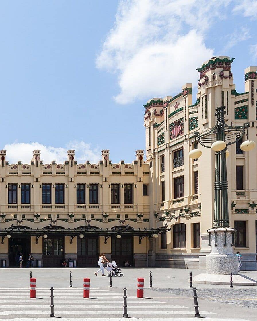 Facciata modernista della Estación del Norte di Valencia decorata con arance in ceramica, accanto all'arena, con gente in calle Xàtiva