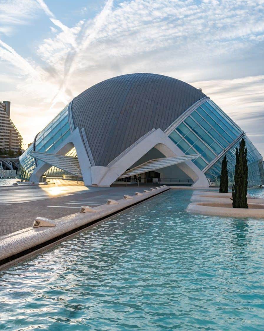 Fachada acristalada y estructura de hormigón del Hemisfèric de la Ciudad de las Artes y las Ciencias de Valencia bajo un cielo despejado a media tarde