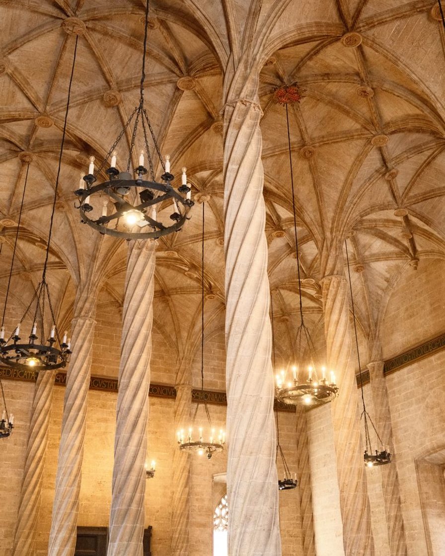 Columnas helicoidales de piedra de la Sala de Contratación de la Lonja de la Seda de Valencia, con la luz entrando por los ventanales góticos