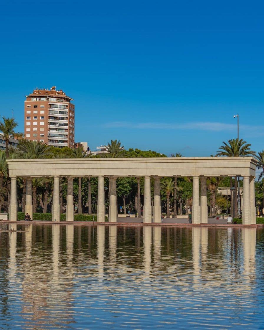 Familias y ciclistas paseando por el antiguo cauce del río Turia convertido en jardín en Valencia, un sábado por la mañana con árboles y césped