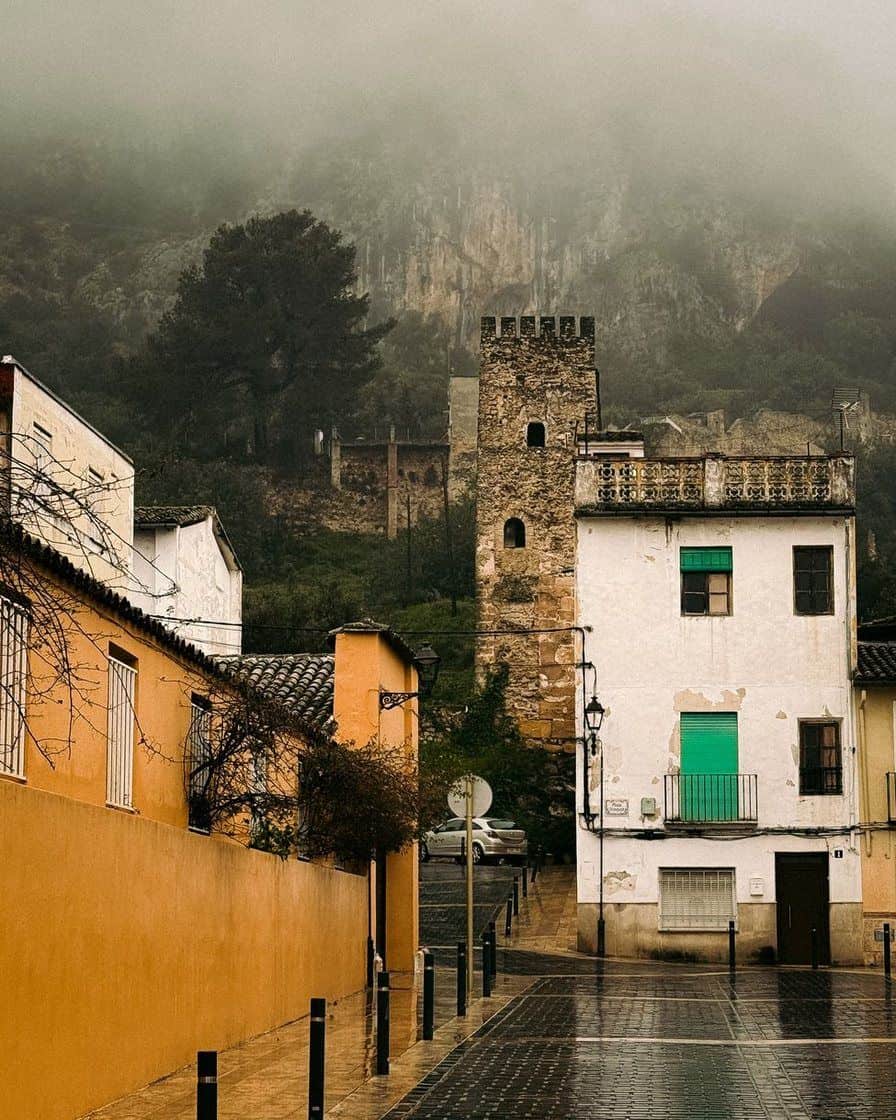Murallas del castillo de Xàtiva recorriendo la cresta del monte sobre la ciudad, con almenas y torres de piedra entre pinos